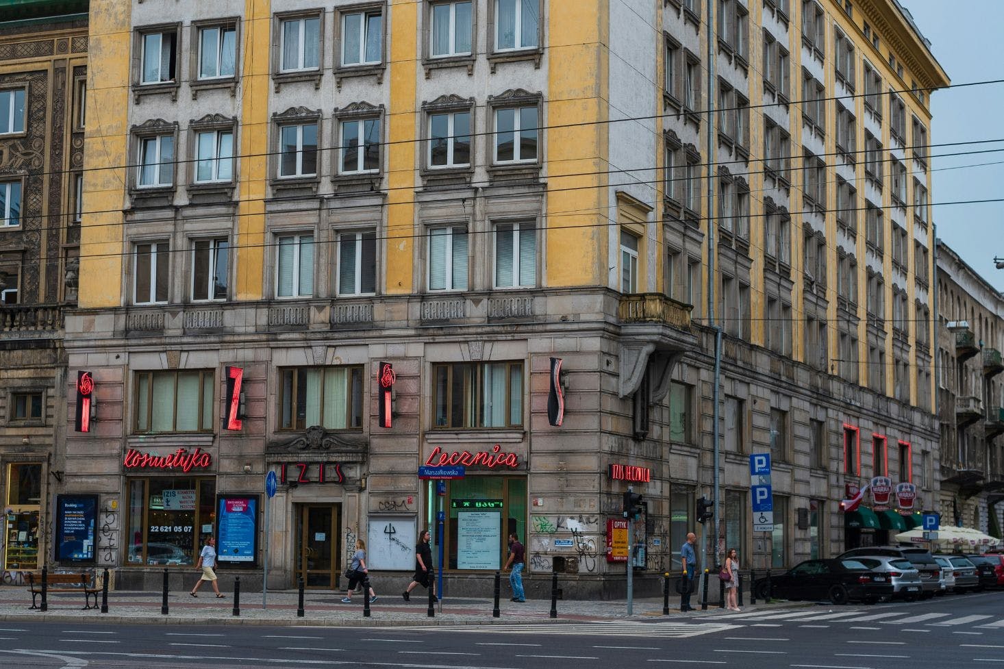 A busy shopping street in Warsaw Old Town with locals passing by the old building with shops