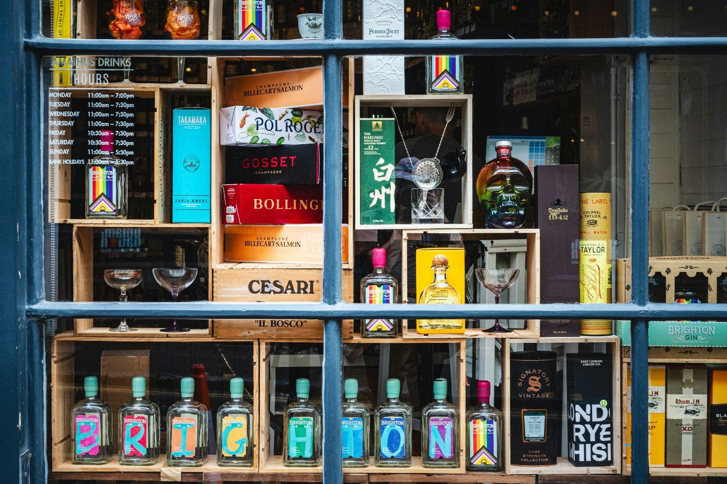 Window display of a drink shop in The Brighton Lanes featuring unique bottles, glasses, and stylish boxes