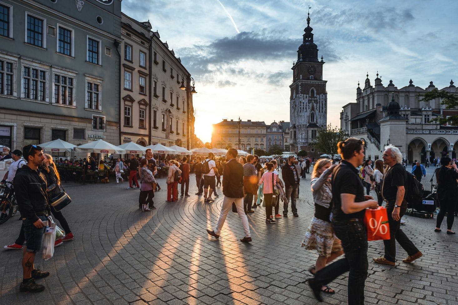 Busy Main Market Square in Krakow with a lot of pedestrians with shopping bags passing by