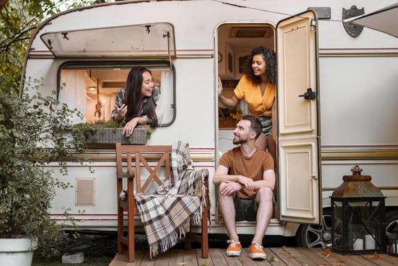 Three friends enjoy their time in a cozy caravan