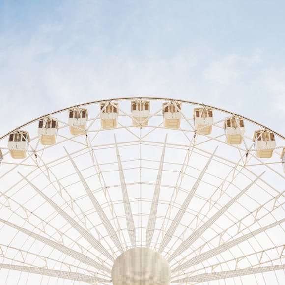 Close-up of white big giant wheel against blue sky