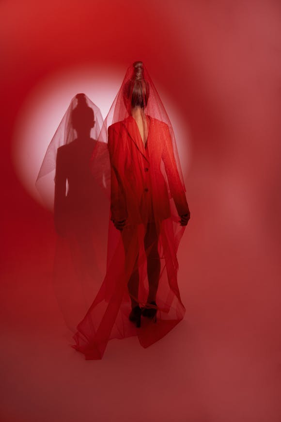 Surrealist photo of a model in bright red clothes