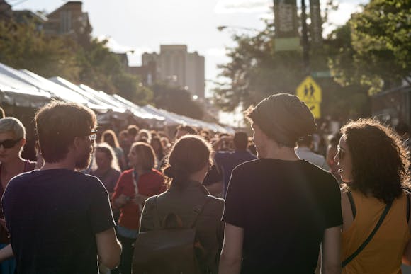 Crowds enjoying live music, food stalls, and a vibrant street festival atmosphere