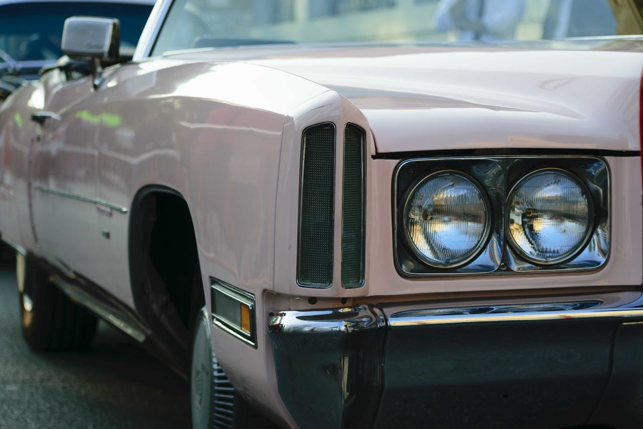 Closeup shot of the headlights of a beige antique car at a car show