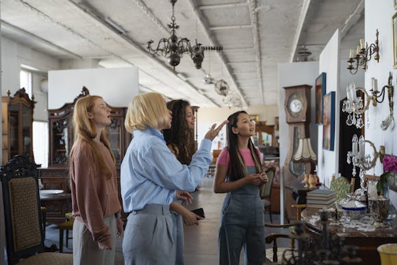 A group of young women exploring interior products, admiring household items in a well-lit, spacious showroom at Foire de Rouen