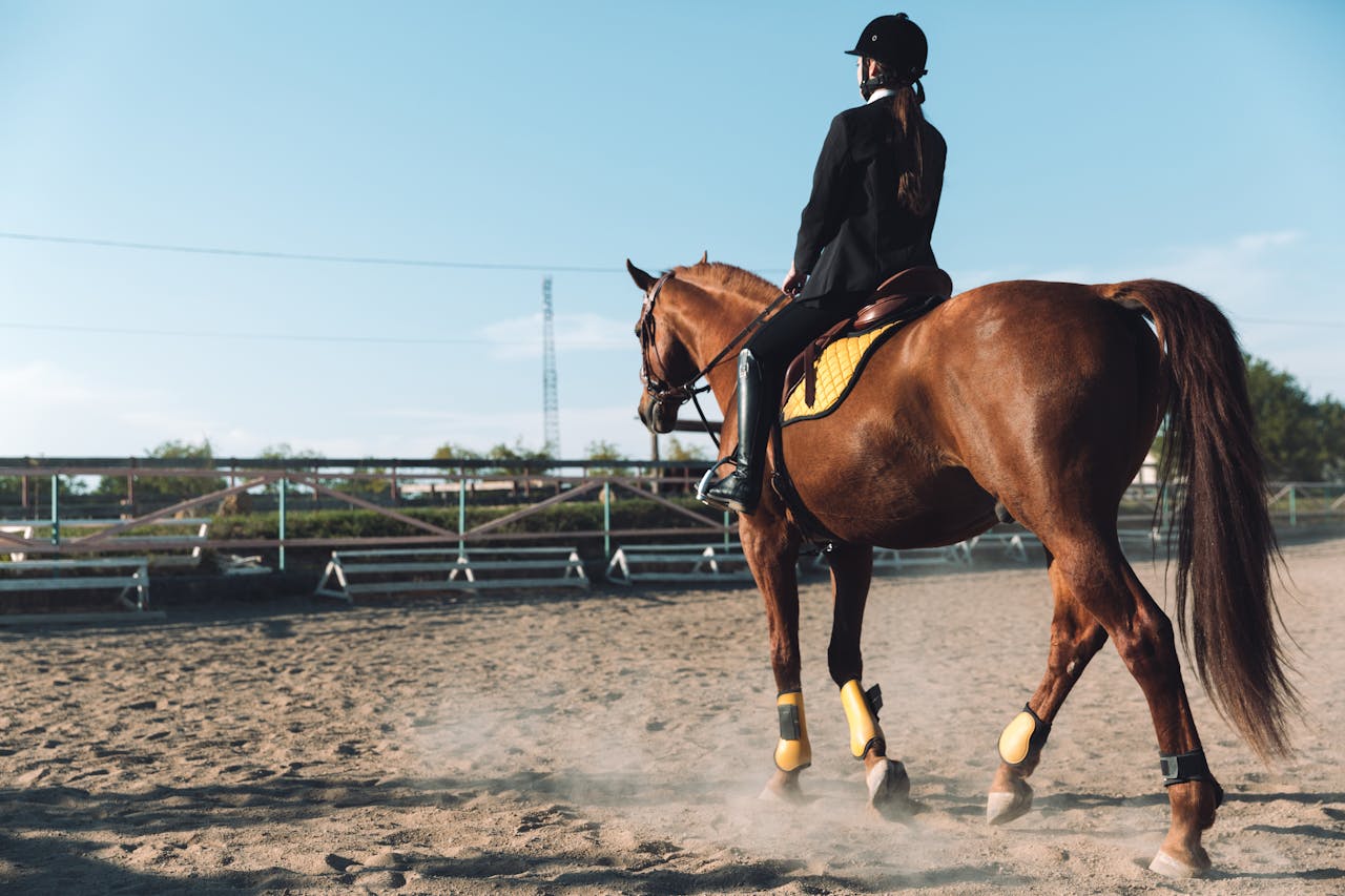 An equestrian riding a horse on dirt outdoors during the Kentucky Derby