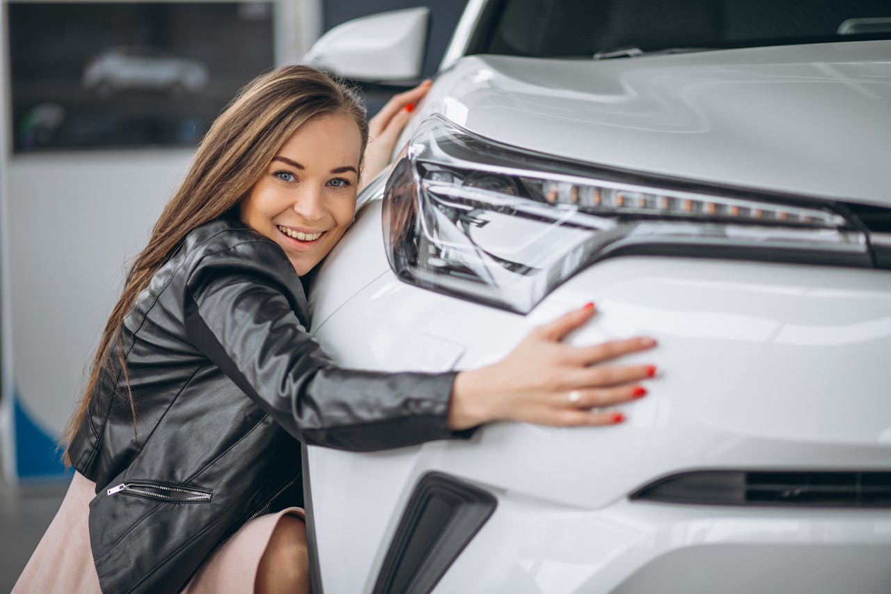 A woman hugging a modern car with a sleek design at Automobile Barcelona