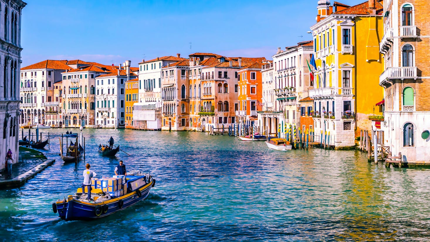 Landscape of a Venice canal, boats and buildings during a sunny day