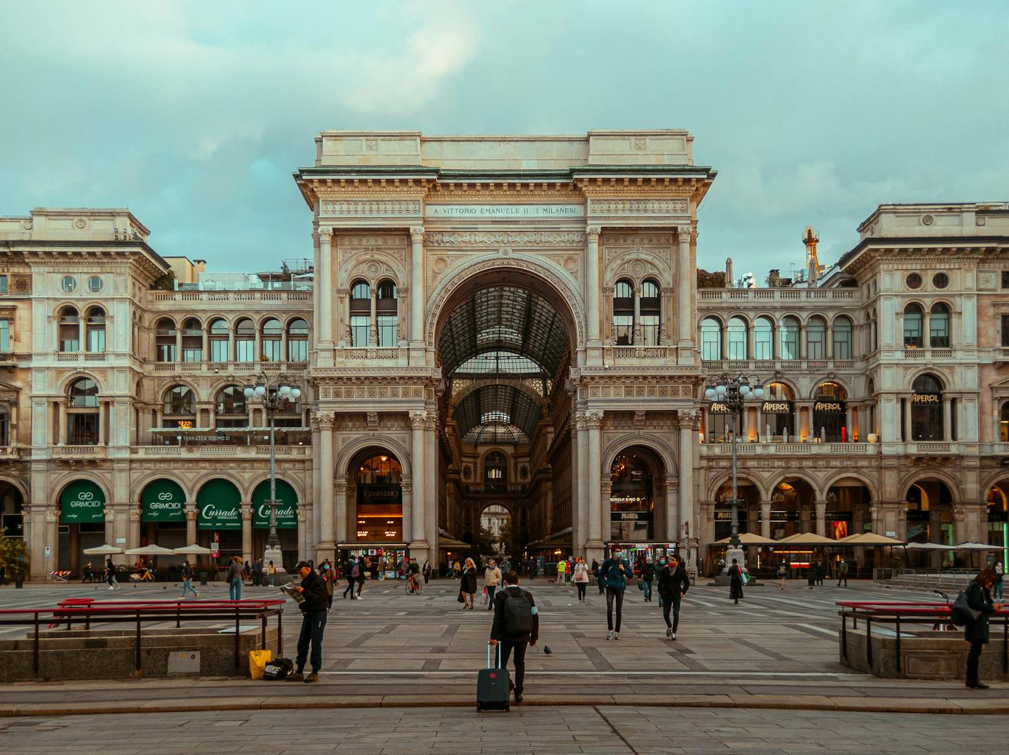 Street view of Galleria Vittorio Emanuele II in Milan, with people walking in front