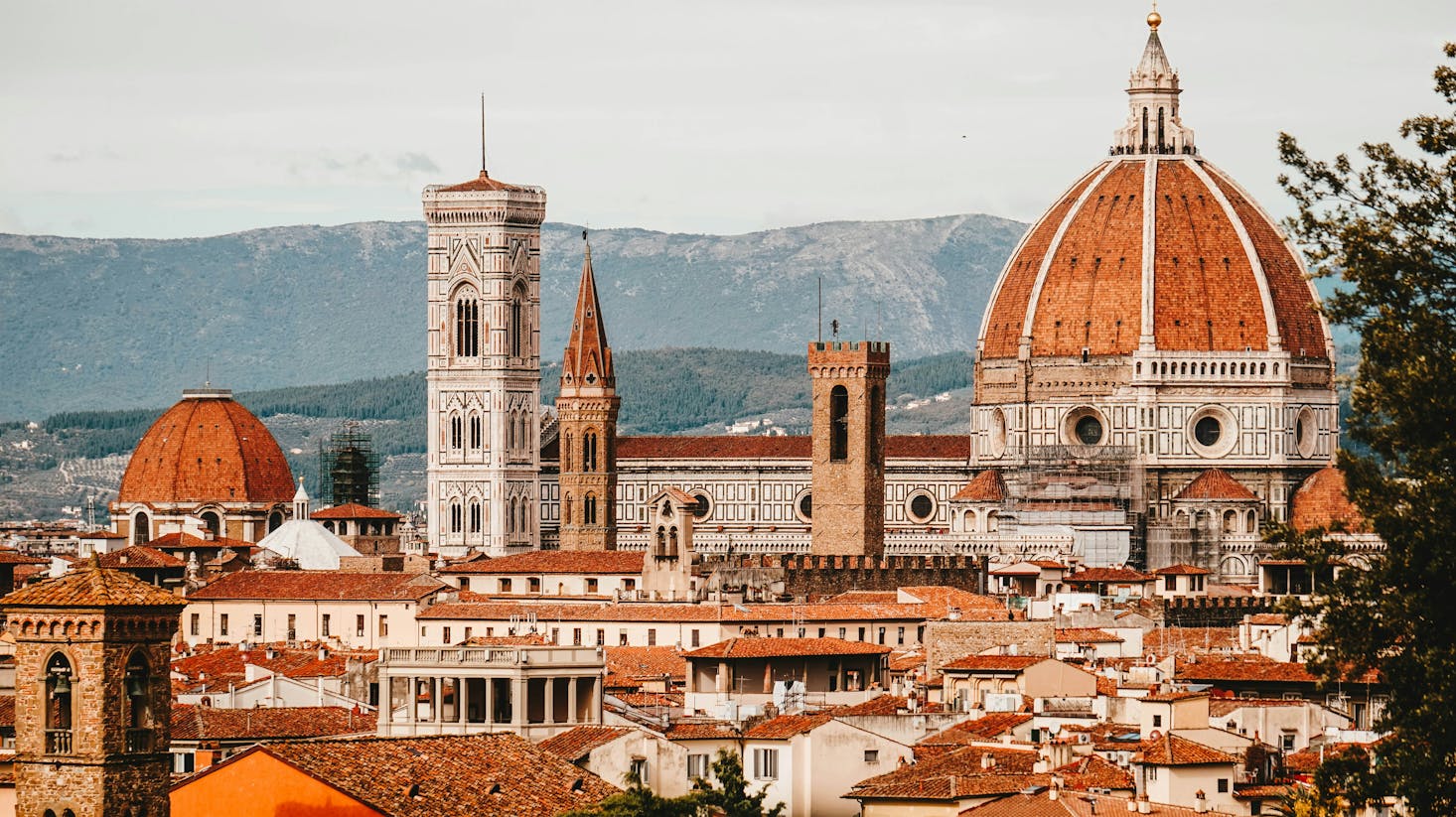 Florence Cathedral (Cattedrale di Santa Maria del Fiore) with its red-tiled dome, marble facade, and surrounding architecture