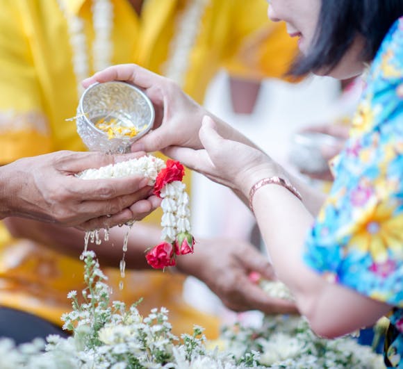 Close-up of hands pouring water during Songkran festival