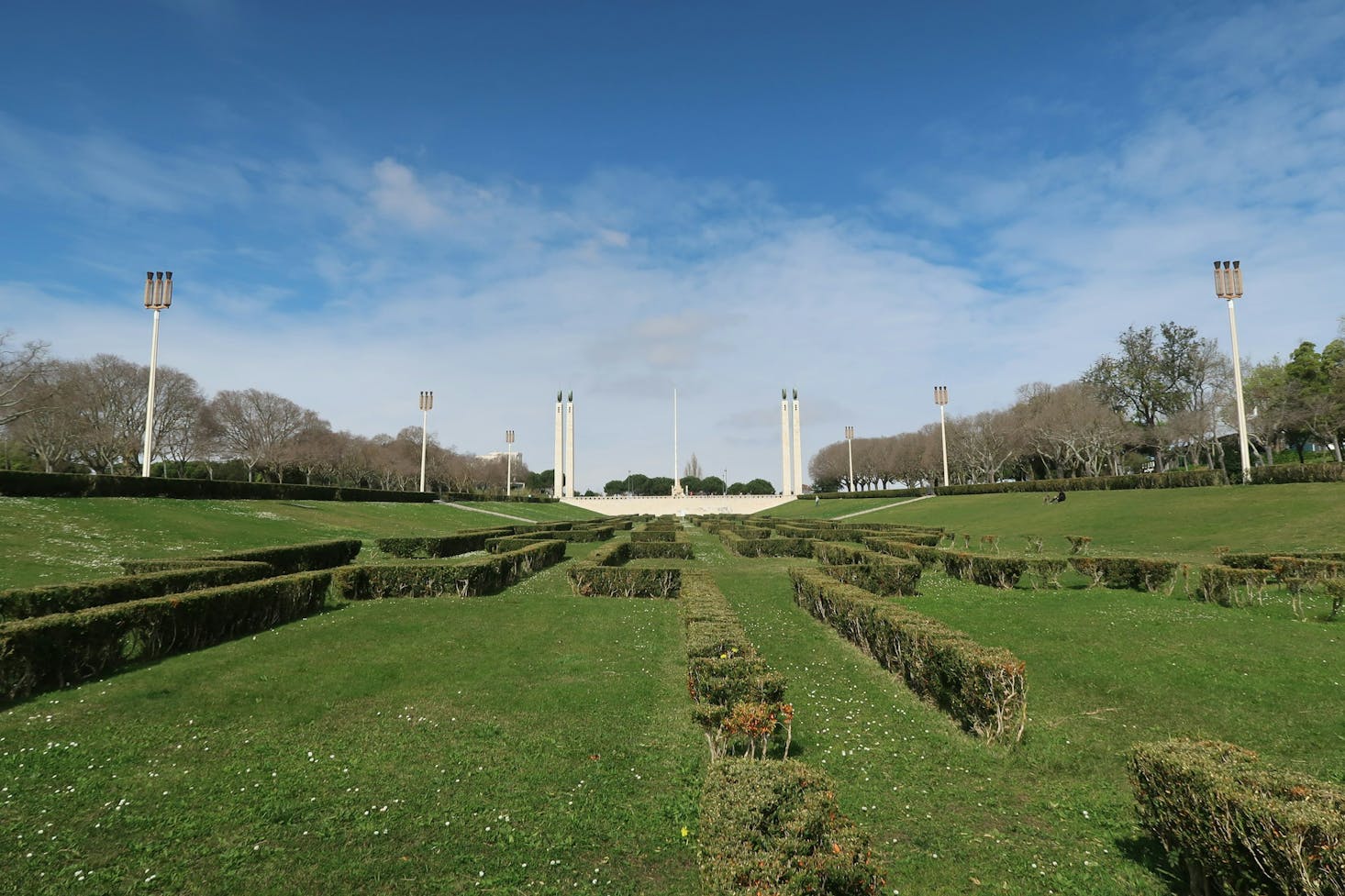 Large park with hedges and a monument at the end
