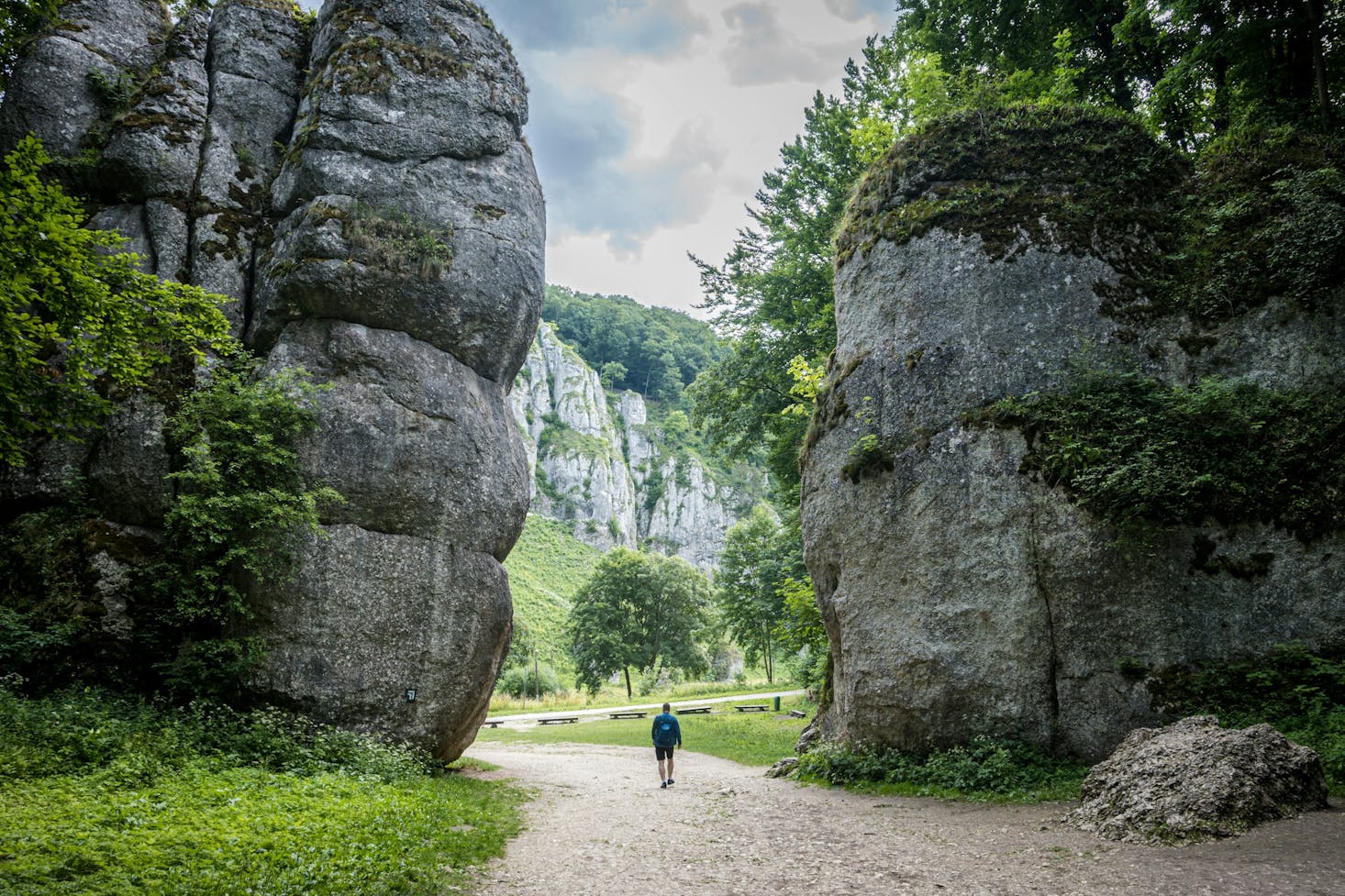 Person walking in between high rock walls in an expansive Krakow park