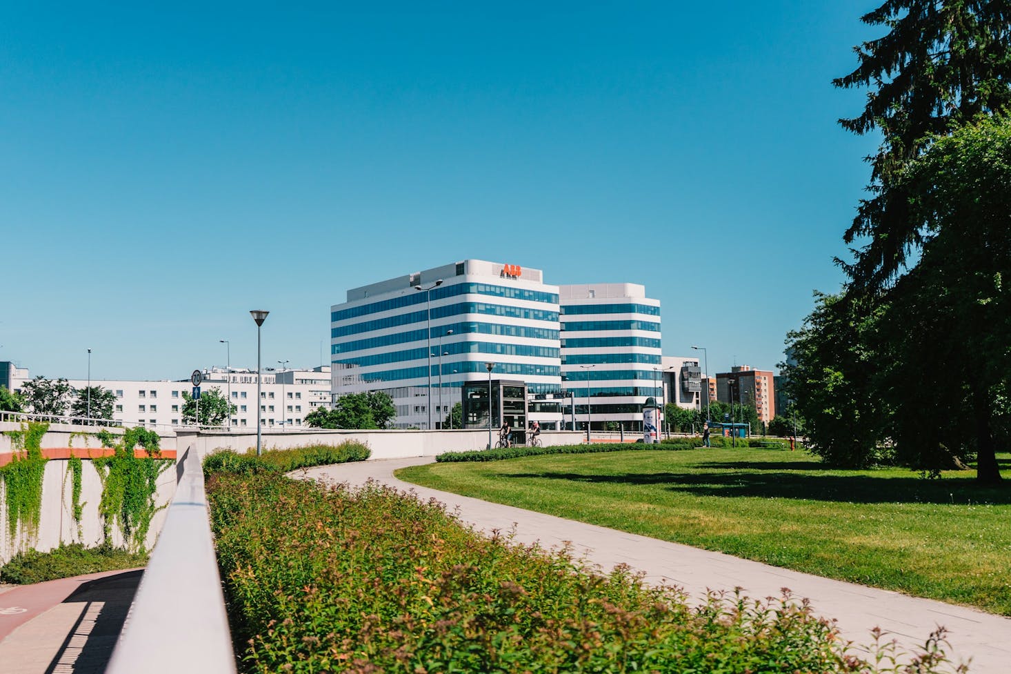 Park pathway passing in front of a modern building with many windows