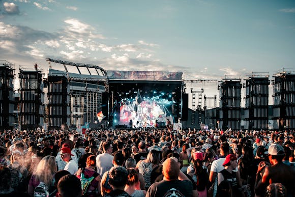 A concert with thousands of visitors at an open-air festival during the day