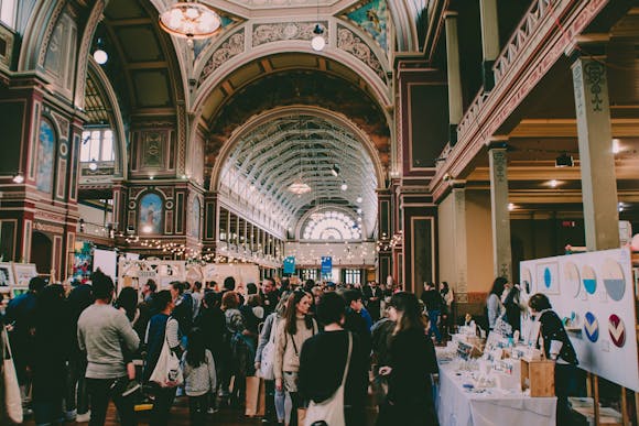 A big crowd at an exhibition in a beautiful palace