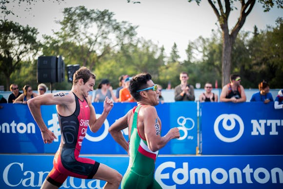 An intense marathon showdown between 2 runners, with spectators in the background