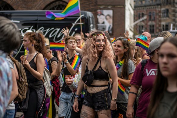 Glammed up Pride participants at the NYC Pride Parade carrying rainbow flags