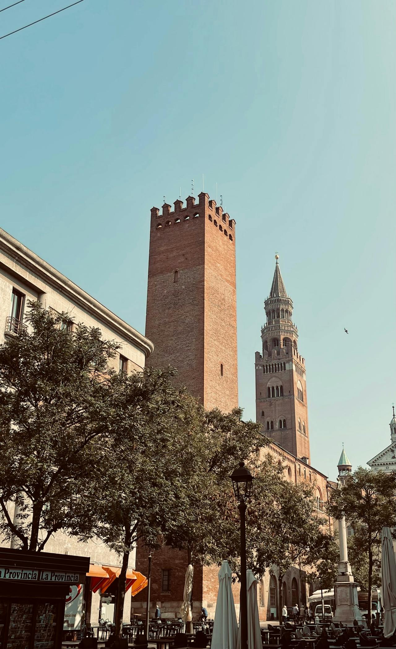 Historic brick towers rise above the tree-lined streets, blending in the charm of Cremona.