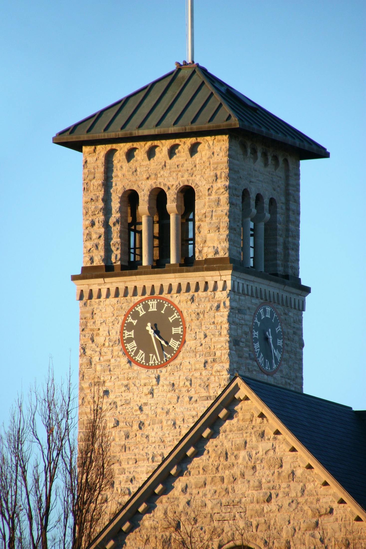 Charming stone clock tower basking in the golden glow of the setting sun.