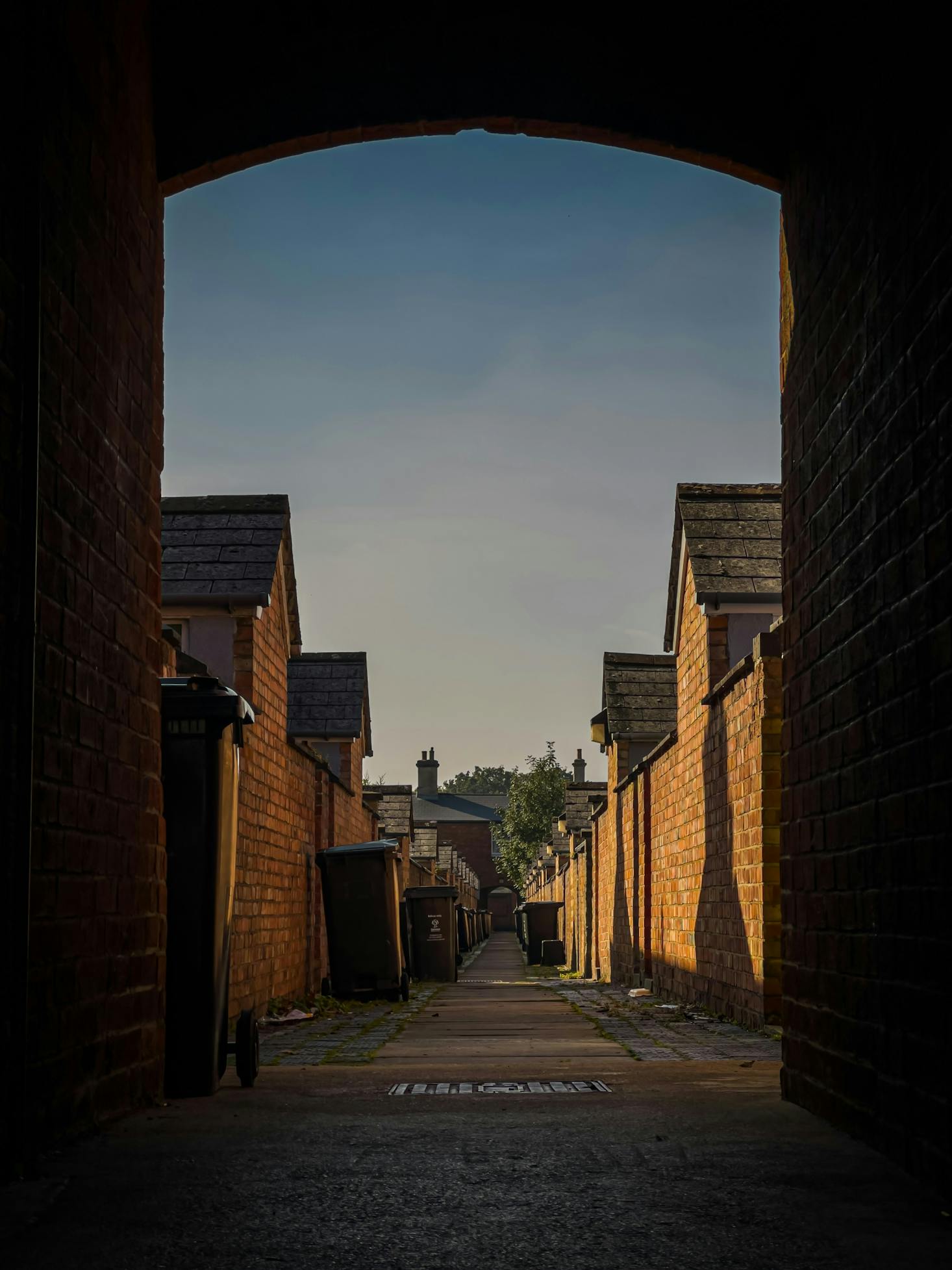 A narrow alley way with brick buildings on either side in Swindon.