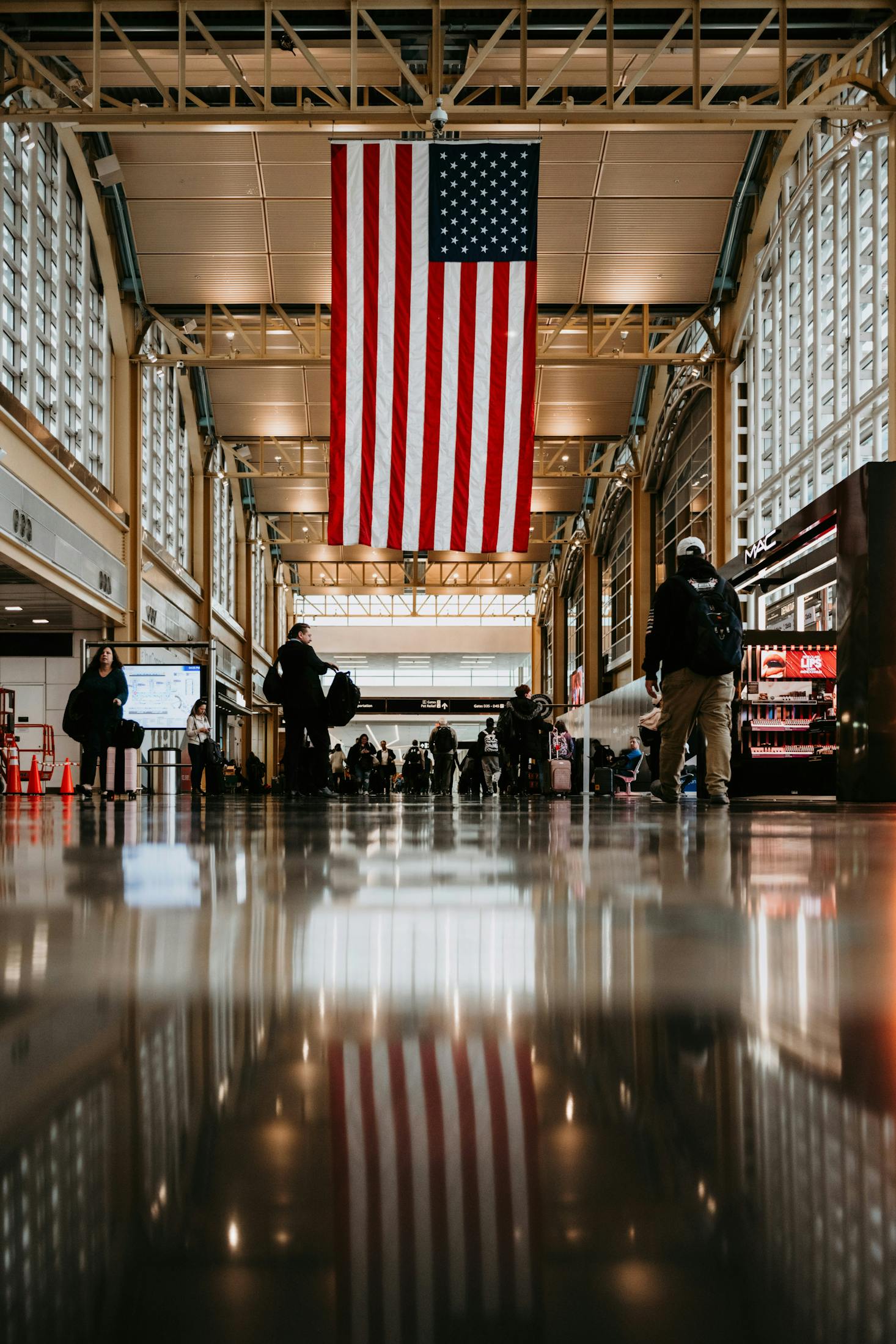 Ronald Reagan Washington National Airport (DCA) adorned with a large American flag hanging from the ceiling, reflecting on the polished floor below.