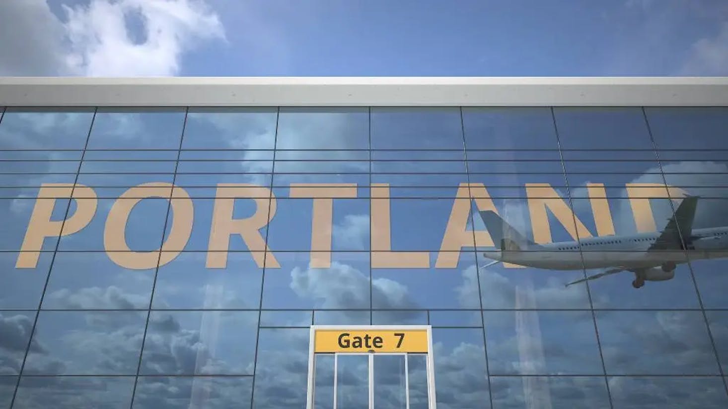 Glass facade of Portland Airport with a large "PORTLAND" sign