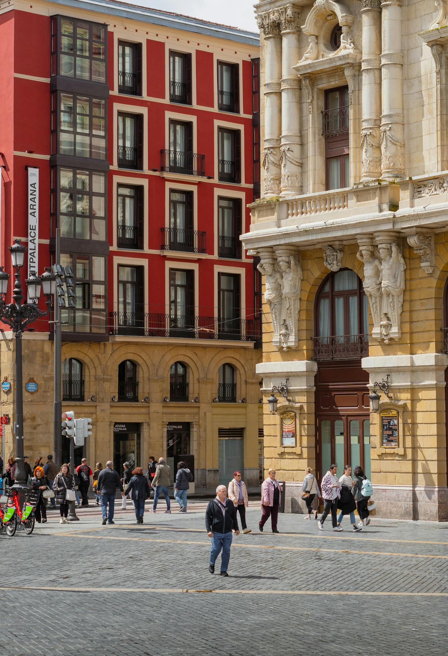 People walk along a street of colorful architecture in Old Town, Bilbao