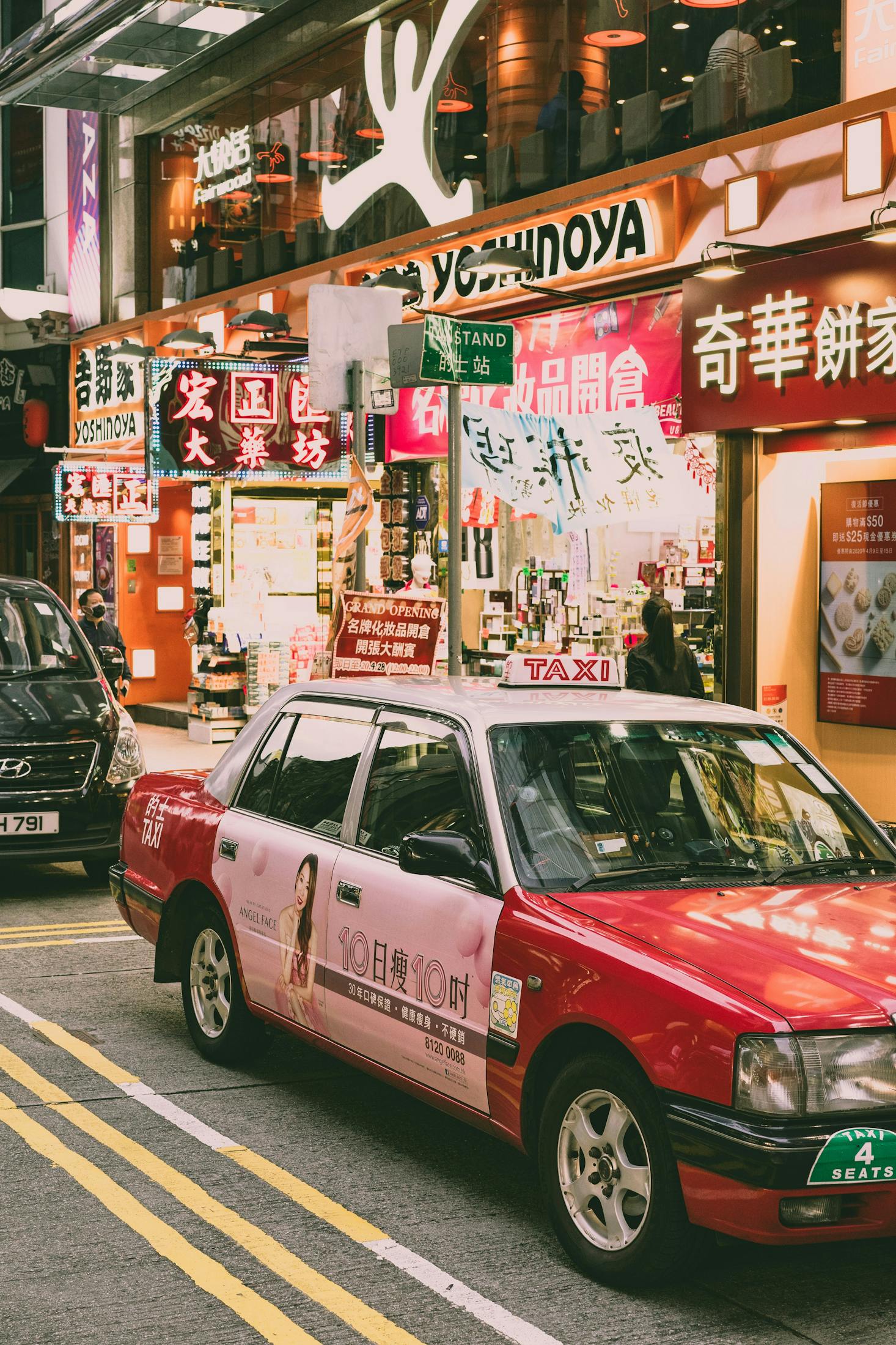 Busy street scene in Causeway Bay, featuring a red and white taxi