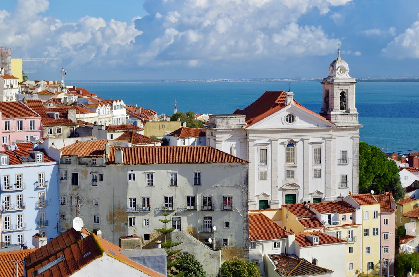 Panoramic view of Alfama, Lisbon, showcasing its iconic red-tiled rooftops