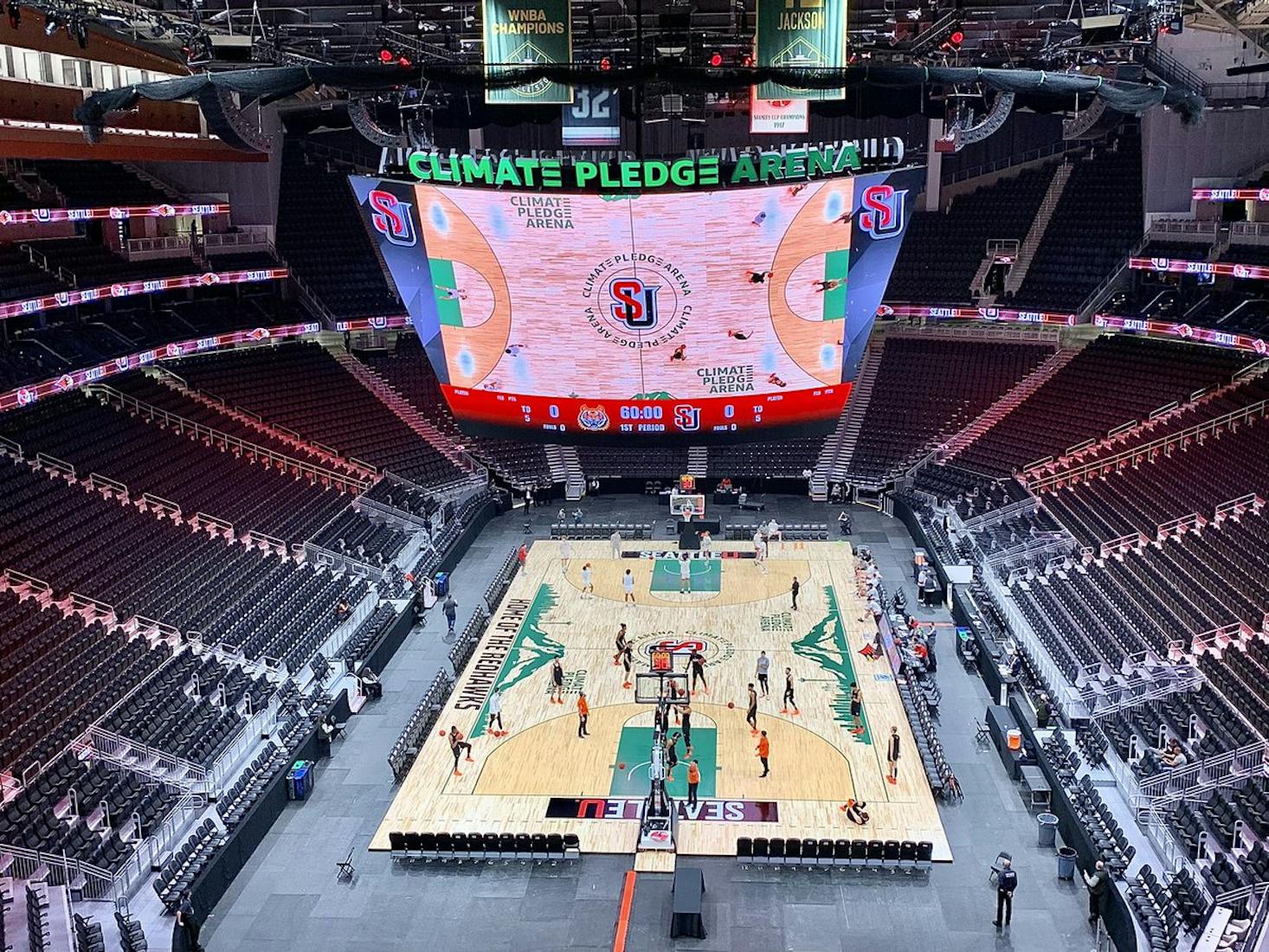 The interior of Key Arena, featuring a basketball court with players practicing.