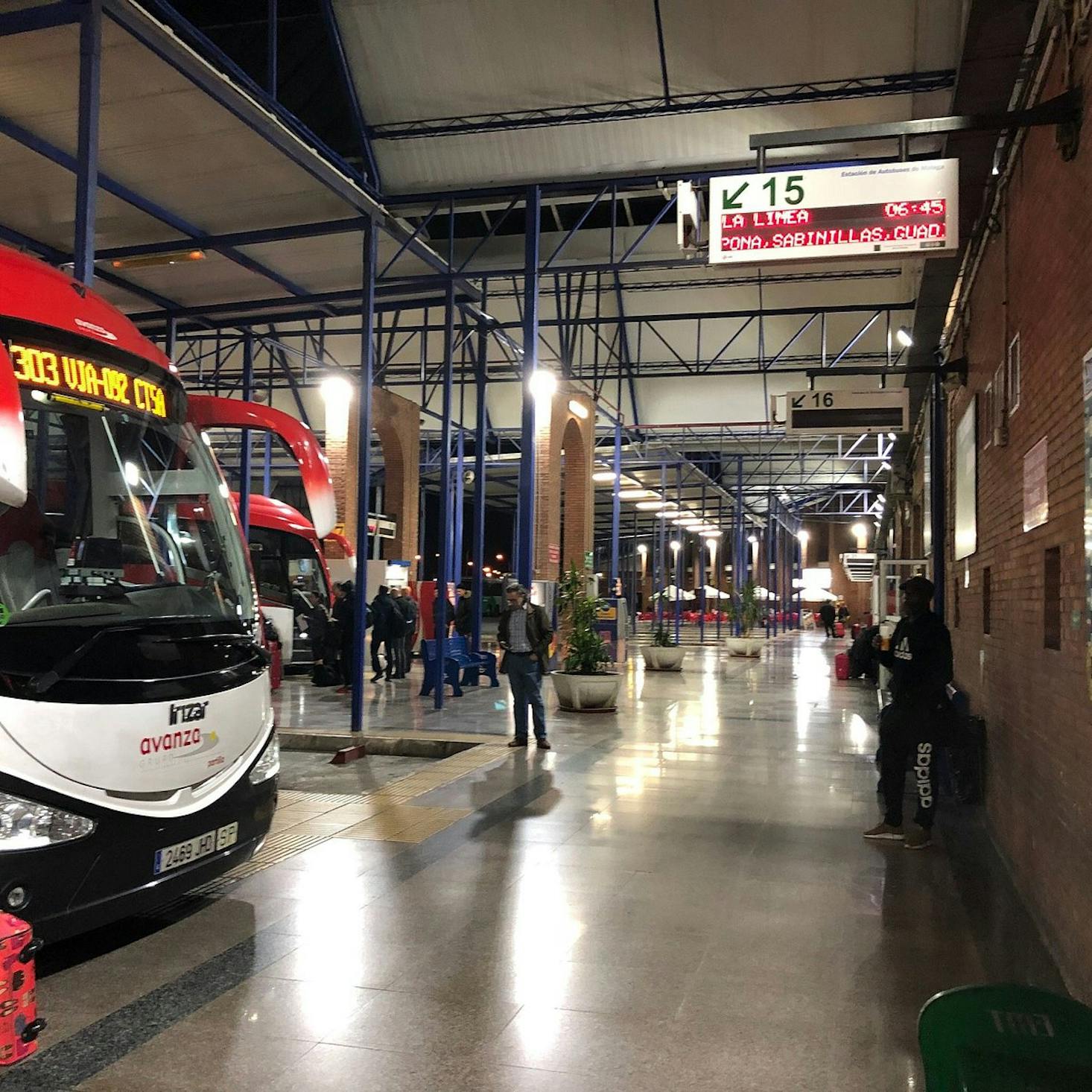 The Málaga Bus Station, with buses parked at the platforms, and passengers waiting.