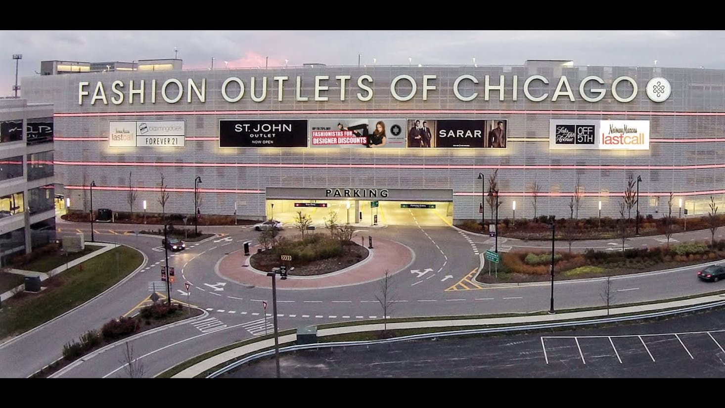 The exterior of the Fashion Outlets of Chicago, with large signs for various stores.