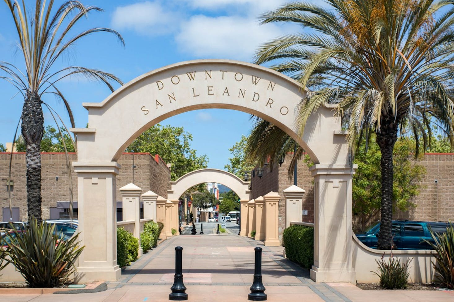 The entrance arch to Downtown San Leandro, framed by palm trees.