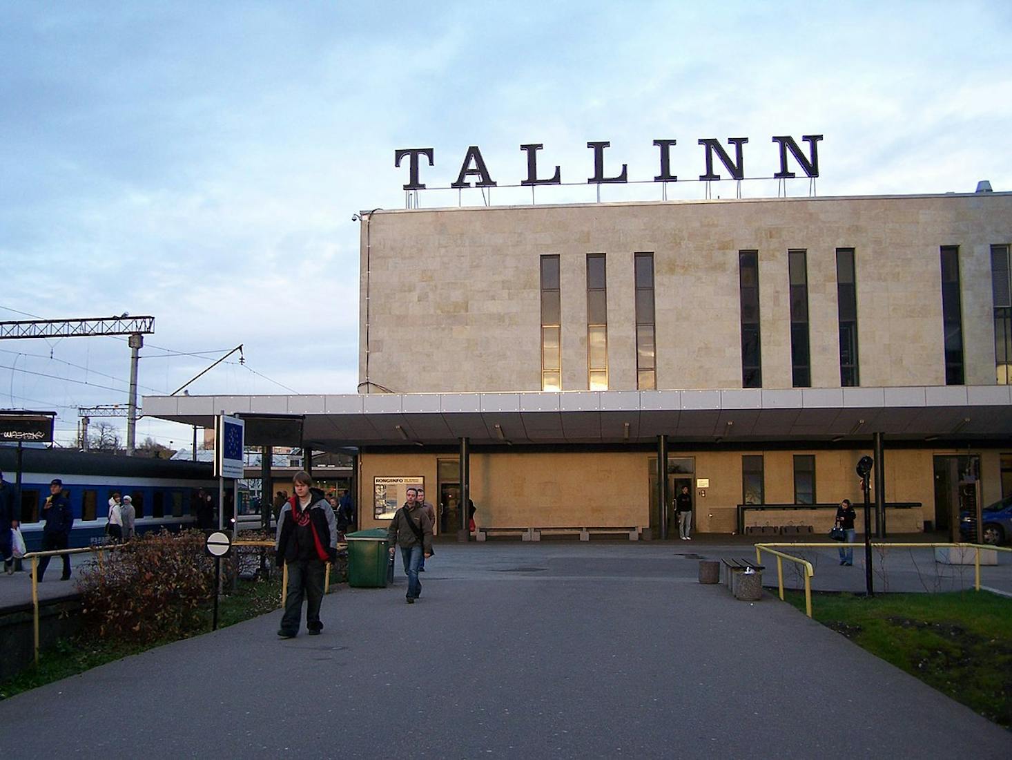 The exterior of a train station in Tallinn, with people walking in front