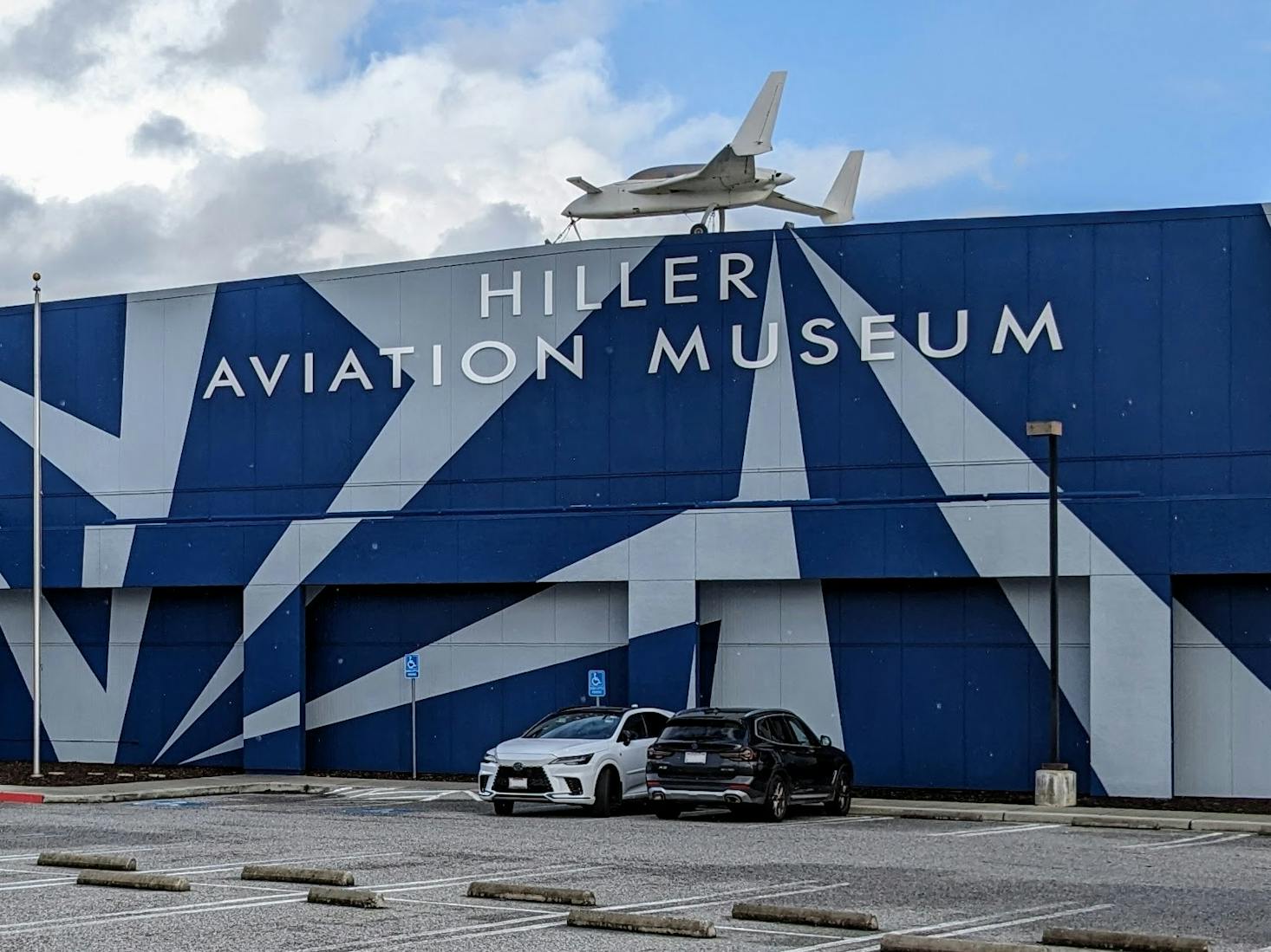 Hiller Aviation Museum, featuring a bold blue and white design with an aircraft displayed on the roof