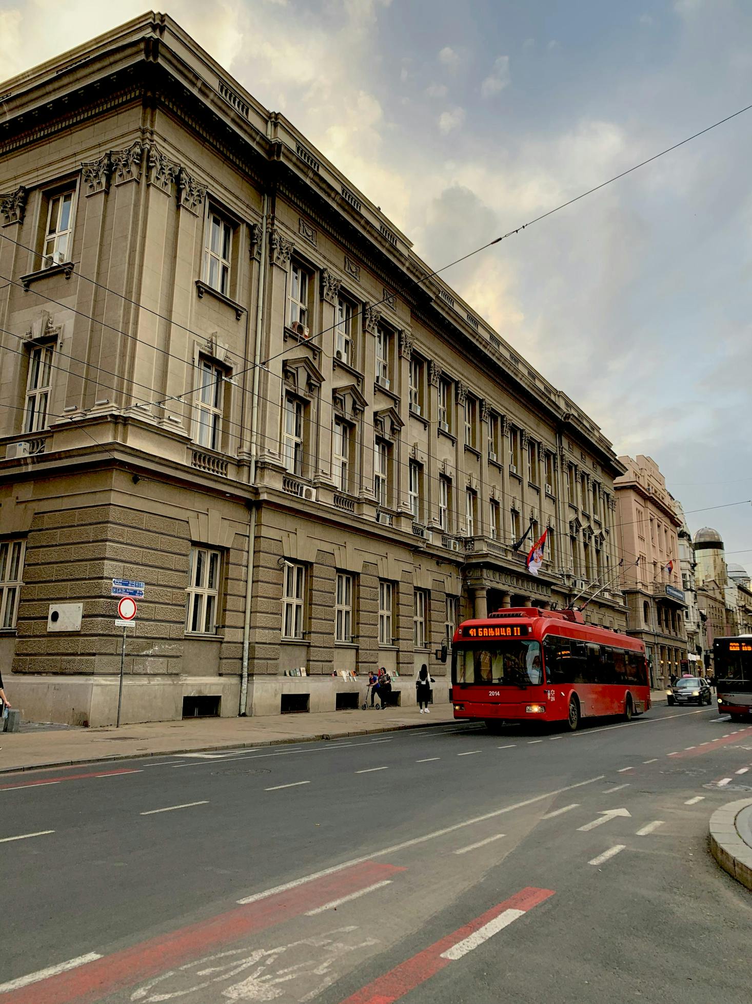 A red bus parked in front of the University of Belgrade in Serbia