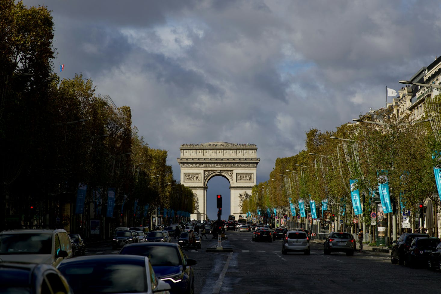 Les Champs Elysée entourée d'arbres avec une vue sur l'Arc de Triomphe