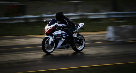 Biker speeding down a street on a motorcycle, captured with a slight blur to show motion