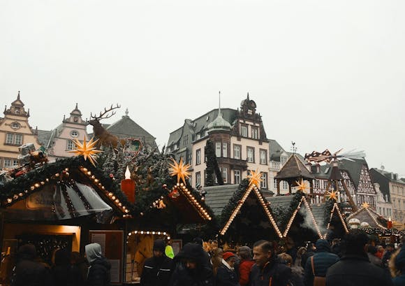 Festive Christmas market stalls illuminated with lights, surrounded by visitors enjoying the holiday spirit at the Hamburg Christmas Market