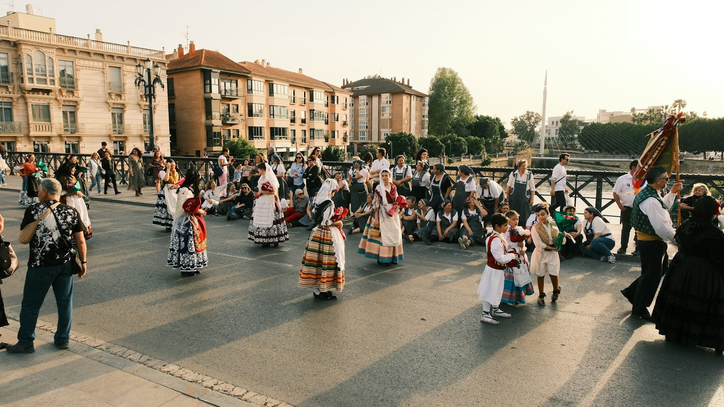 People adorned in colorful clothing in a square in Murcia, Spain