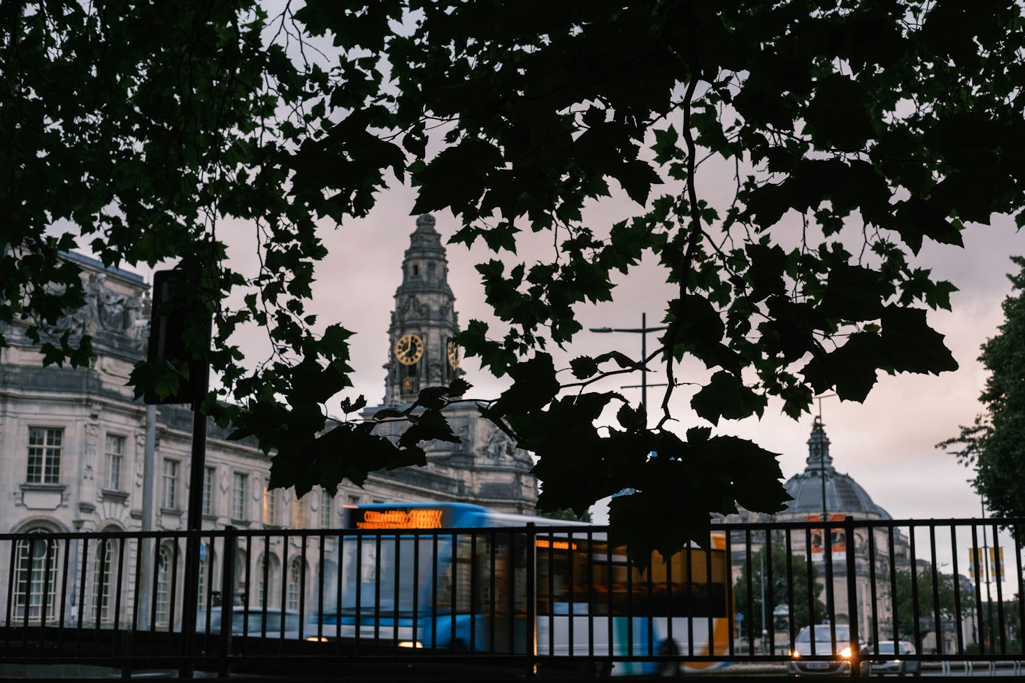 Bus traveling on the Cardiff streets at sunset