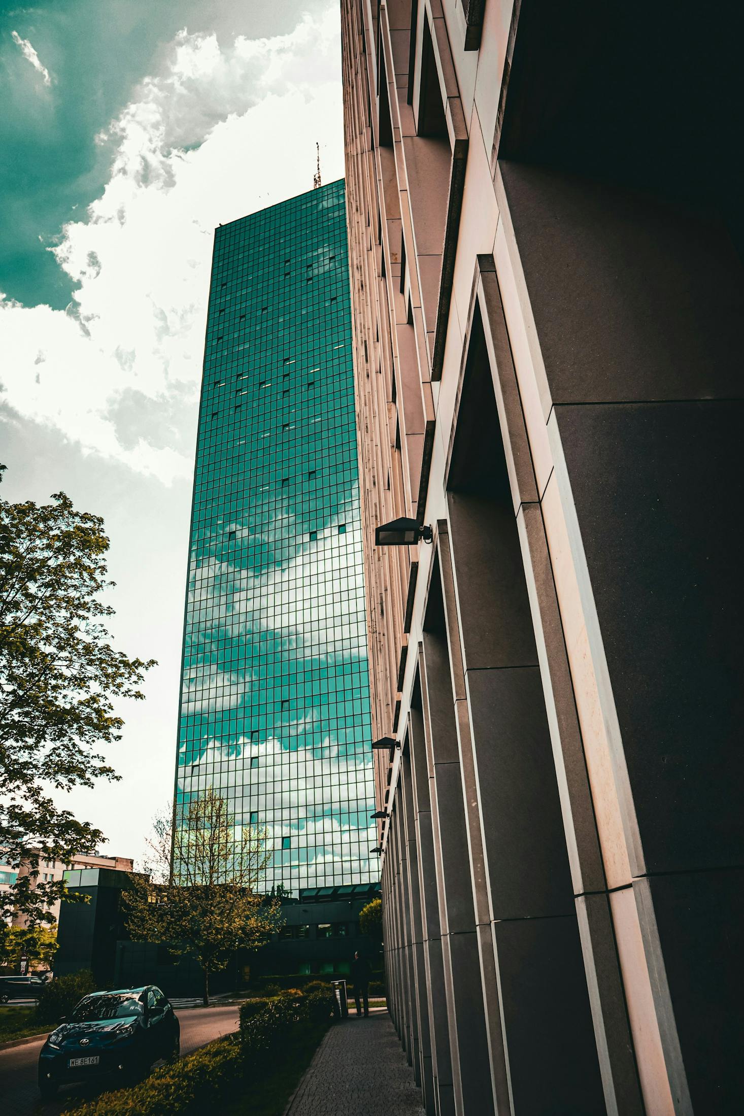 A glass highrise in Warsaw, Poland stands tall against a cloudy sky