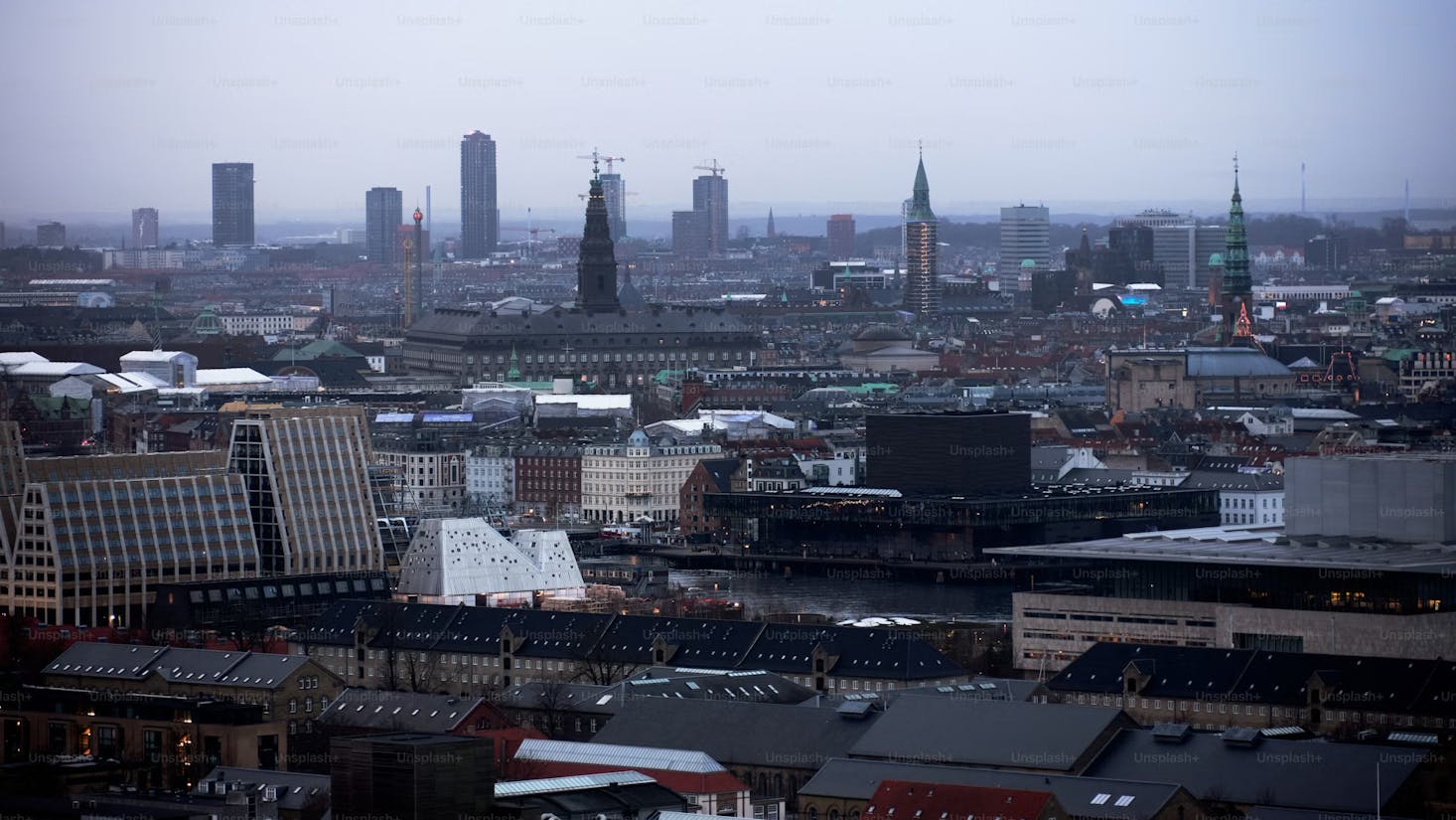 Multiple skyrises in the cityscape of Copenhagen, Denmark against gray sky