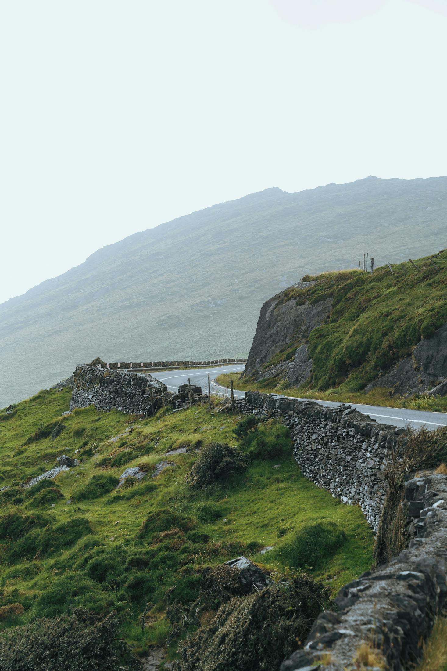 Winding cliffside road on a misty day near Cork Bus Station