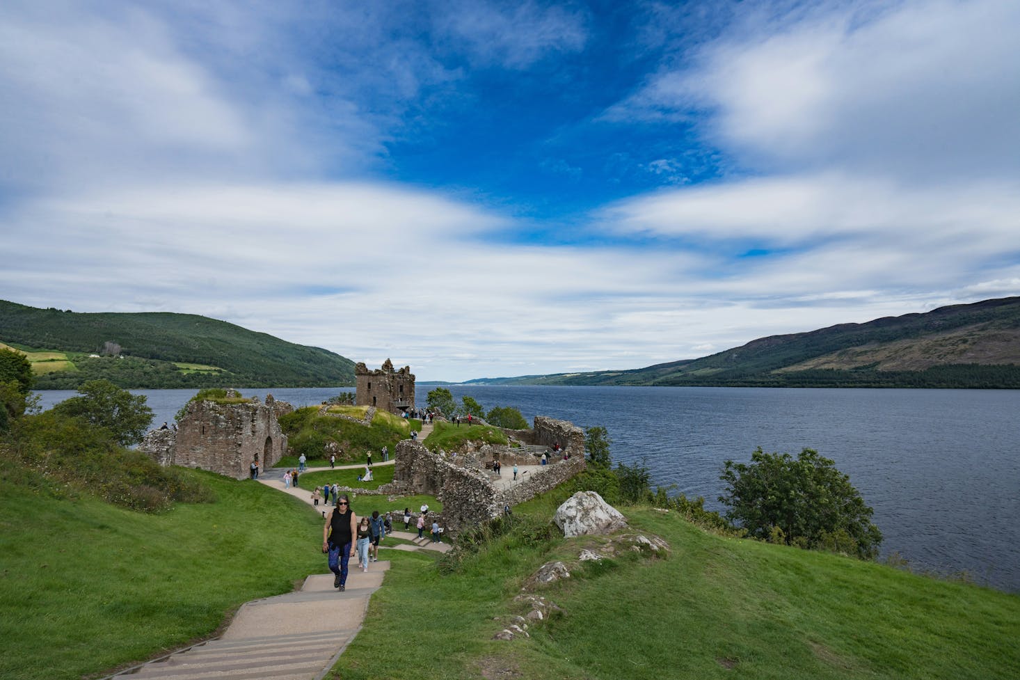 Urquhart Castle in Inverness with water views and a few people wandering around.