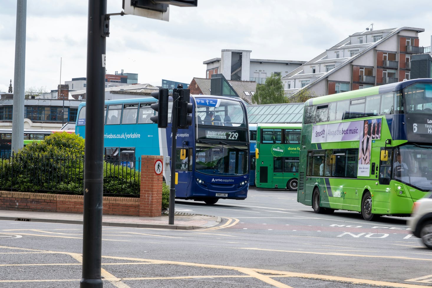 Colorful buses lining up outside Leeds Bus Station on a cloudy day 