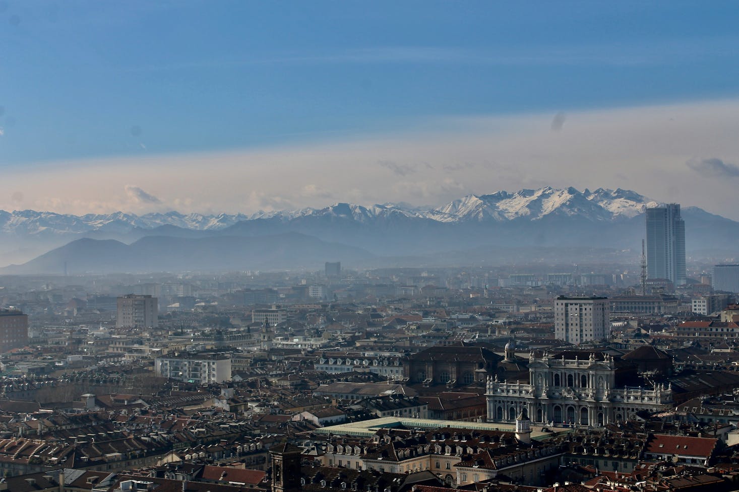 Vista dall'alto sulla città di Torino, con le Alpi innevate sullo sfondo