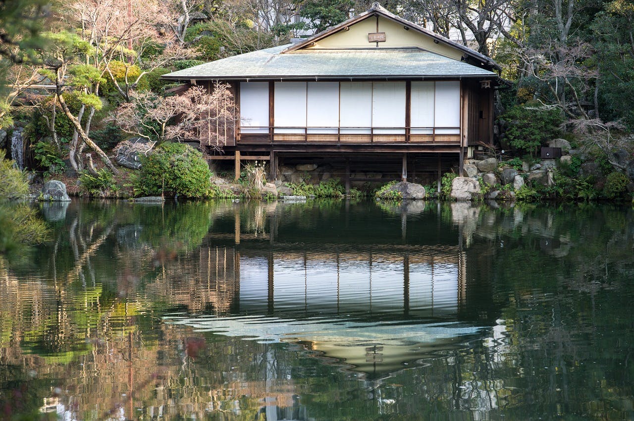 A traditional Japanese tea house surrounded by a serene garden in Kobe.