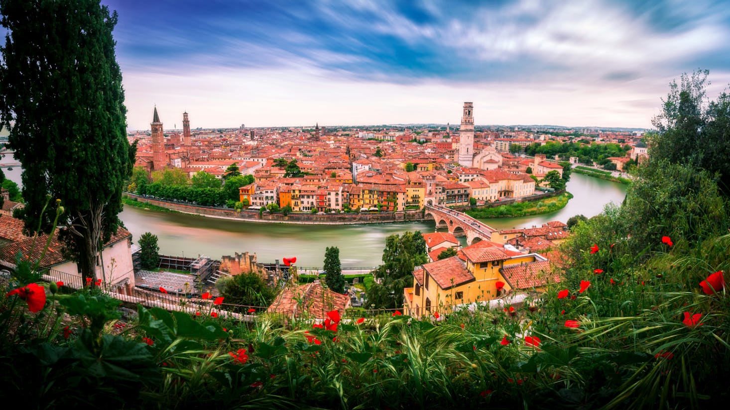 Vista dall'alto sulla città di Verona, con tetti di case ed edifici, fiume Adige e cielo azzurro